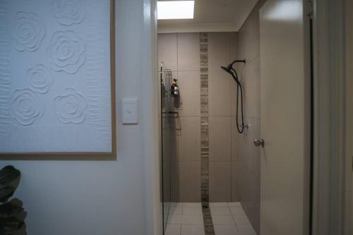 bagno con doccia e porta in vetro di Palms on Patti Apartment a Rockhampton