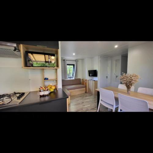 une cuisine avec un comptoir et une table avec des chaises dans l'établissement Mobil Home Premium 3 ch Camping 5 Biscarrosse Mayotte F64, à Biscarrosse