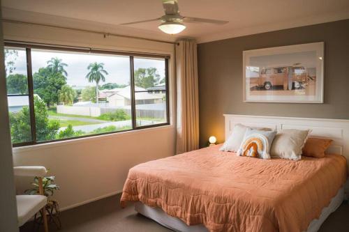 una camera con un letto e una grande finestra di Palms on Patti Apartment a Rockhampton