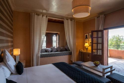 um quarto com uma cama grande e uma janela em Dar Layyina em Azib Oulad Lâdem