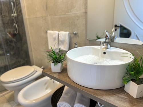 a bathroom with a white sink and a toilet at Vicoletto Fiorito in Porto Empedocle