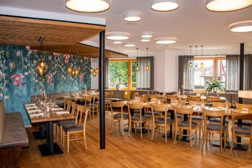 una sala da pranzo con tavoli e sedie in legno di Deutsches Haus Hotel Restaurant Gastwirtschaft Biergarten am Radweg Bermuthshain a Bermuthshain