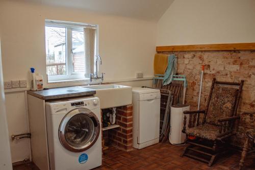 a kitchen with a washing machine and a sink at Family Getaway at Working Farm in Church Fenton