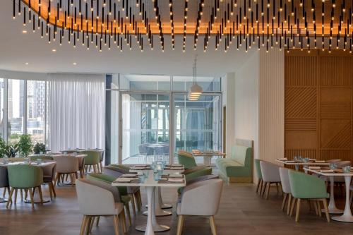 a restaurant with tables and chairs under a chandelier at Holiday Inn Dubai Business Bay by IHG in Dubai