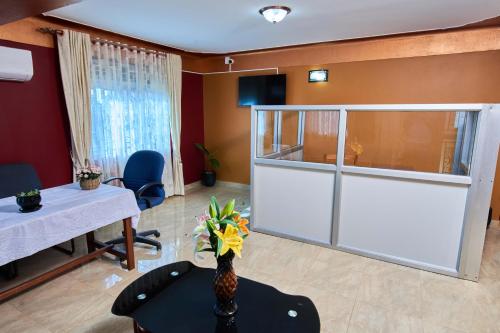 un soggiorno con porta bianca e tavolo di PB & J Guest House Entebbe a Entebbe