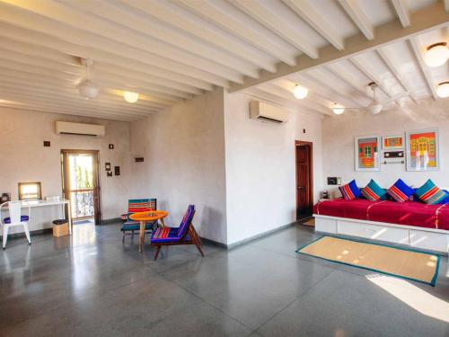a living room with a red couch and a table at Mangaldas Ni Haveli II by The House of MG in Ahmedabad