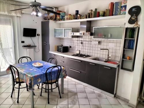 a kitchen with a table with chairs and a sink at [Casa Tizzy] Frontemare in Borghetto Santo Spirito