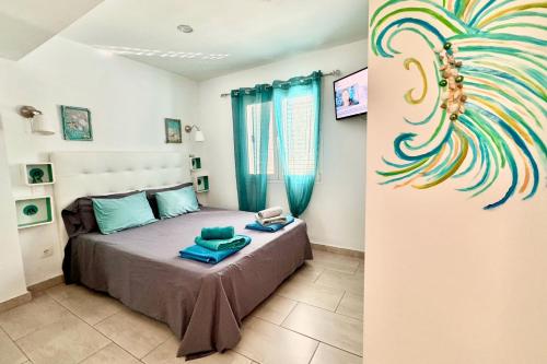 プエルト・デル・カルメンにあるArthouse Sea View - Acquamarina e Zaffiroのベッドルーム1室(ベッド1台付)が備わります。壁には孔雀の絵画が飾られています。