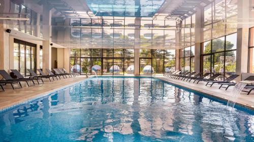 a large swimming pool with chairs in a building at Gori Inn in Gori