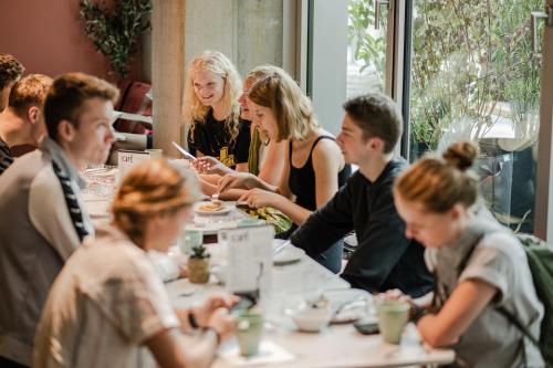 a group of people sitting at a table in a restaurant at Wombat's City Hostel Munich Werksviertel in Munich