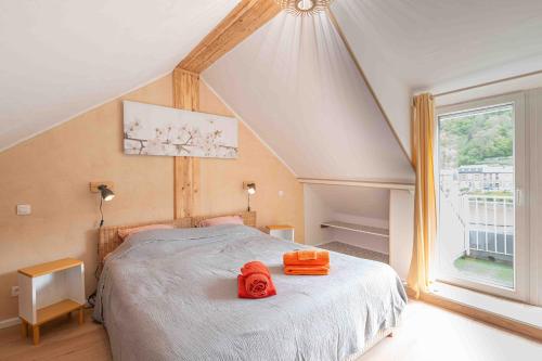 sypialnia z łóżkiem z pomarańczowymi ręcznikami w obiekcie Les Gites Kangourou Dinant w mieście Dinant