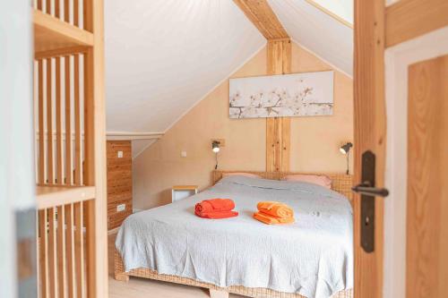 a bedroom with a bed with two orange hats on it at Les Gites Kangourou Dinant in Dinant