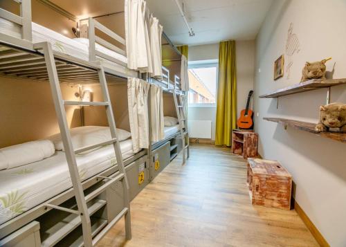 a room with three bunk beds and a guitar at Wombat's City Hostel Munich Werksviertel in Munich