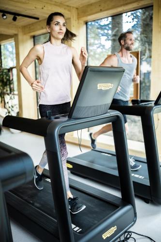 two people on a treadmill in a gym at Hotel Hochschober in Turracher Hohe