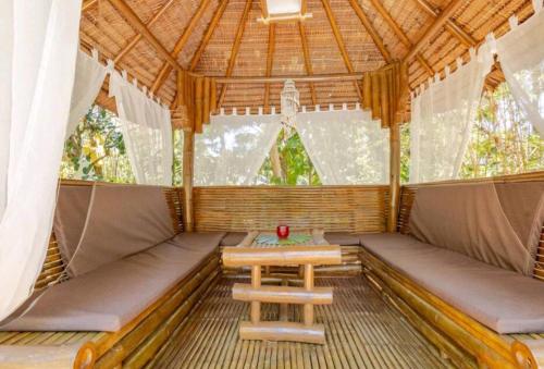 a gazebo with a bench and a table in it at Palmhill Villa in Boracay