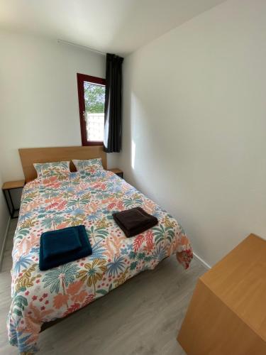 - une chambre avec un lit et une couette colorée dans l'établissement Joli T2 Résidence du Golf avec terrasse, à Bénodet