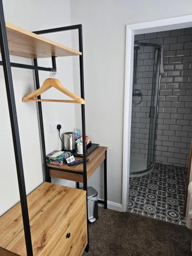a room with a wooden shelf and a shower at The Ivernia hotel in Skegness