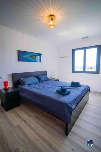une chambre avec un grand lit avec une couverture bleue dans l'établissement Maison neuve, au cœur des vignes, à Sabran