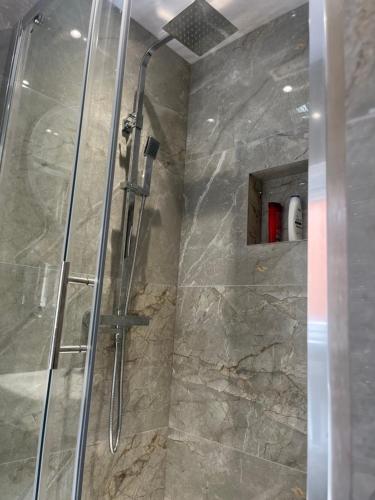 uma casa de banho com um chuveiro e uma porta de vidro em HOMESTAY HAVEN em Leicester