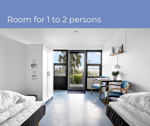 Zimmer mit 2 Betten und einem Esszimmer mit einem Tisch in der Unterkunft Danhostel Rønde in Rønde