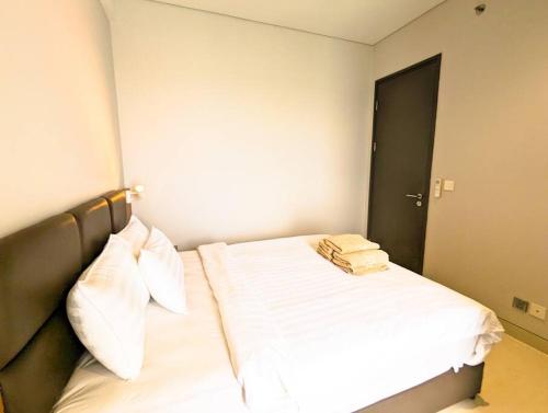 a bedroom with a bed with white sheets and pillows at Lovina 20-AE at One Residence in Batam Center