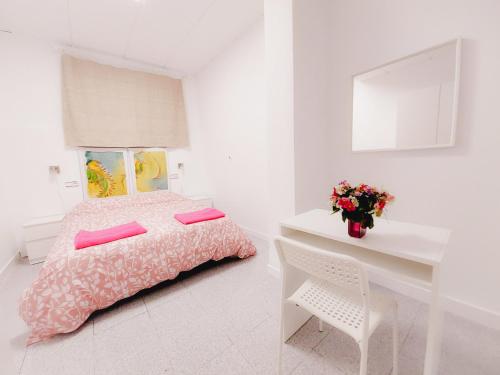 a white bedroom with a pink bed and a white desk at Alojamiento San Juan en Murcia Centro in Murcia