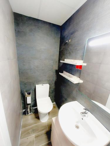 a bathroom with a white toilet and a sink at Alojamiento San Juan en Murcia Centro in Murcia