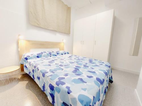 a blue and white bed in a white bedroom at Alojamiento San Juan en Murcia Centro in Murcia