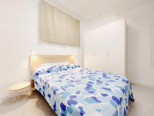 um quarto com um edredão azul e branco numa cama em Alojamiento San Juan en Murcia Centro em Múrcia
