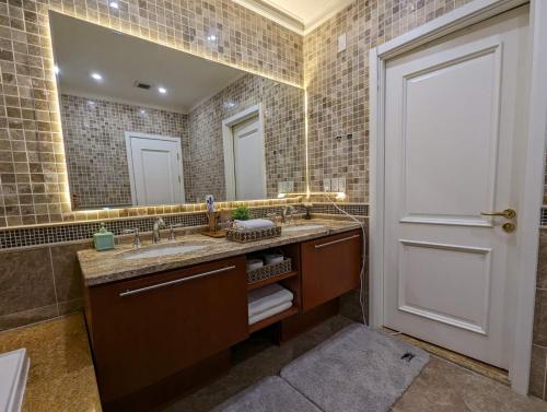 a bathroom with a sink and a large mirror at Buddha Vista Luxury apartment in Ulaanbaatar