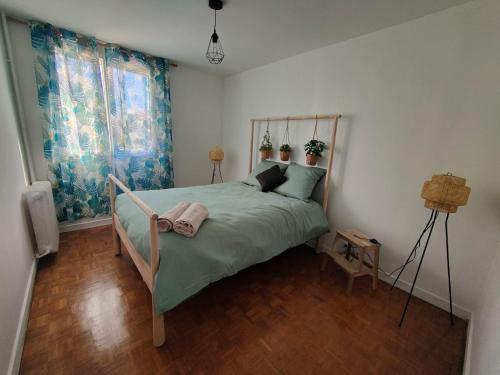 une chambre avec un lit avec une couette verte dans l'établissement eden green, à Seyssinet-Pariset