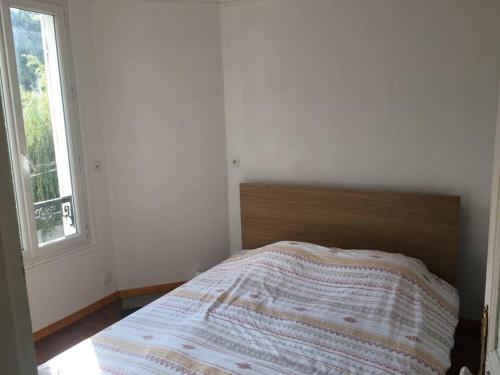 un lit dans une chambre blanche avec une fenêtre dans l'établissement Maison 6-8 personnes à 15 minutes de Paris, à Sannois