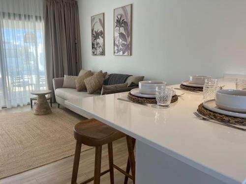 a white living room with a table and a couch at Apartamento Fuerteventura in Villaverde
