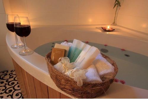 a basket of books and a glass of wine on a bath tub at Oak Shade in Bet Leẖem HaGelilit