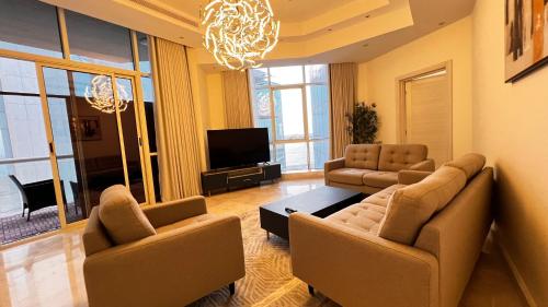 sala de estar con 2 sofás y TV en شقة غرفتين وصاله مطله على البحر برج ابحر ريزيدنس 1 en Obhor