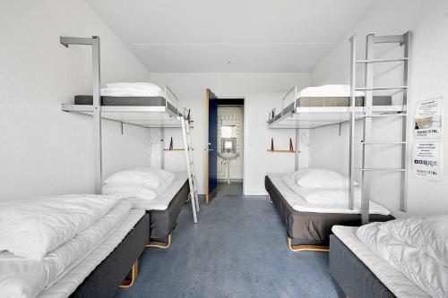 a room with three bunk beds and a hallway at Danhostel Rønde in Rønde