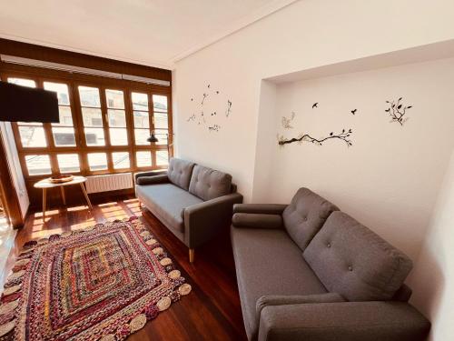 ein Wohnzimmer mit 2 Stühlen und einem Sofa in der Unterkunft MartinVidal 2 in Luarca