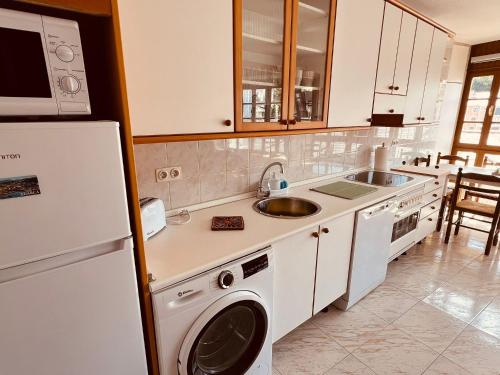 eine Küche mit einer Waschmaschine, einer Spüle und einem Kühlschrank in der Unterkunft MartinVidal 2 in Luarca