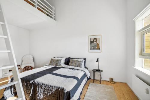 ein weißes Schlafzimmer mit einem Bett und einer Treppe in der Unterkunft Come Stay 3BR - Havudsigt m.plads til 5 personer in Hørsholm