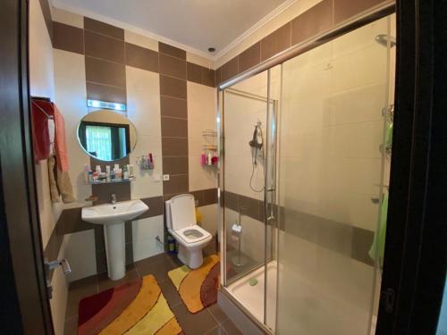 a bathroom with a shower and a toilet and a sink at Karven Four Seasons in Chok-Tal