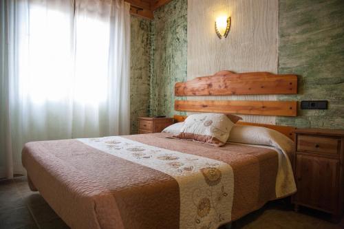 a bedroom with a bed and a window at La Derrubiá in Villamalea