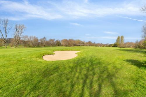 a golf course with a hole in the grass at Come Stay 3BR - Havudsigt m.plads til 5 personer in Hørsholm