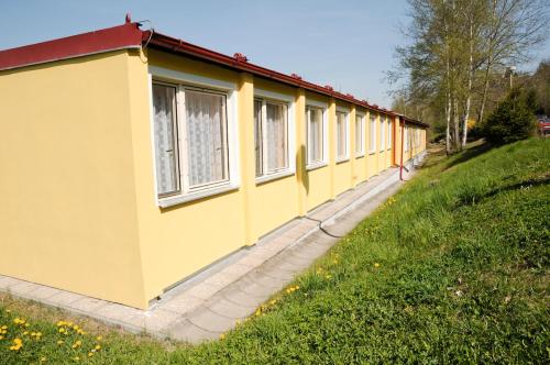 un edificio amarillo con ventanas al costado de una colina en Ubytovna Český Krumlov, en Český Krumlov