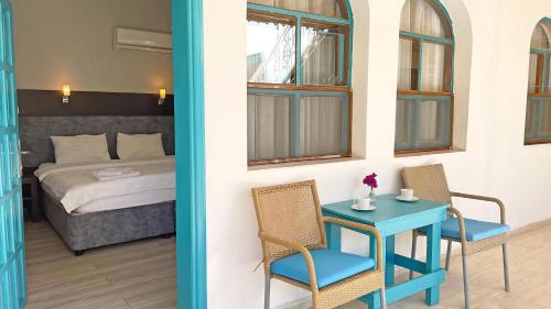 a room with a table and chairs and a bed at Jasmin Pansiyon Çıralı in Cıralı