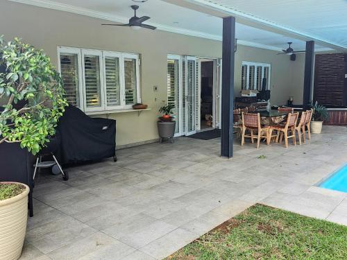 a patio with a table and chairs and a pool at Umhlanga Lodge in Durban