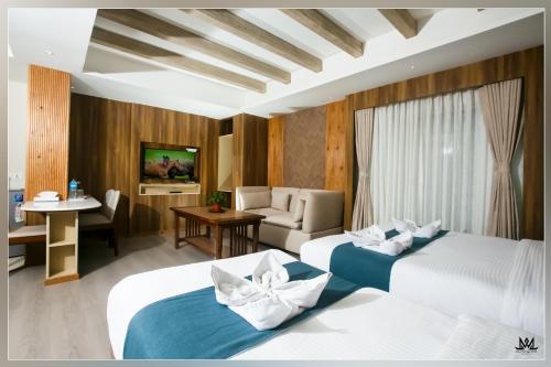 Habitación de hotel con 2 camas y sofá en Hotel Maya Boutique and Apartment, Thamel en Katmandú