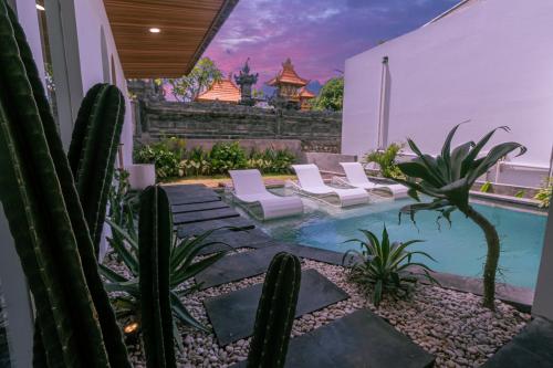 a backyard with a swimming pool and cactus at Samastiti Bingin in Uluwatu
