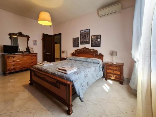 a bedroom with a bed and a dresser and a television at B&B La Magnolia in Acilia