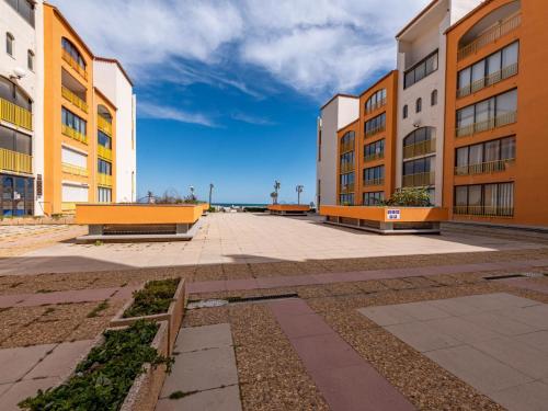 une rangée de bâtiments avec bancs dans une cour dans l'établissement Apartment Palm Beach-2 by Interhome, au Barcarès