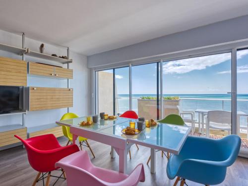 a dining room with a table and colorful chairs at Apartment Casino-5 by Interhome in Lacanau-Océan